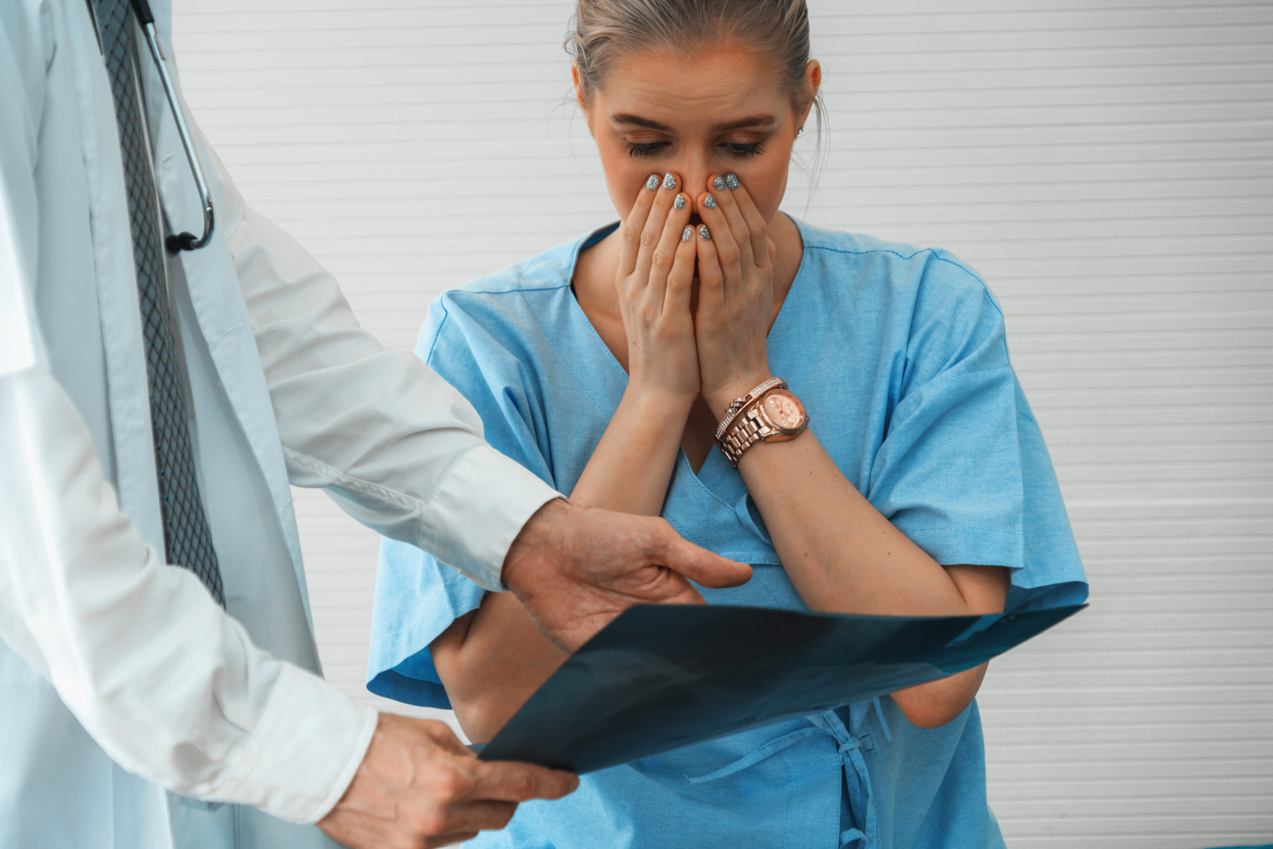 A doctor reviewing a medical error made during a surgery with a patient at a hospital in the Philadelphia area